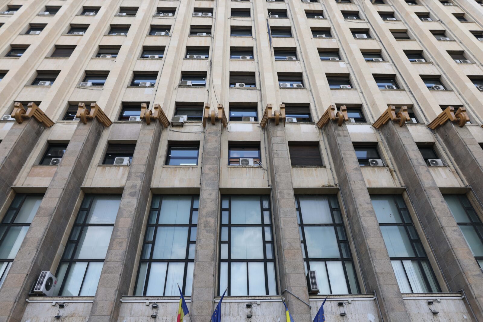 Office building facade in Bucharest with flags at the entrance.