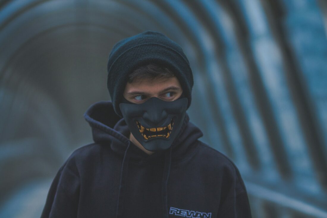 a man wearing a black mask and a black hoodie