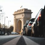 cars on road near brown concrete arch during daytime