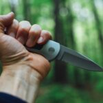 person holding gray and black knife