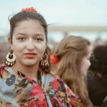 smiling woman in blue red and white floral shirt