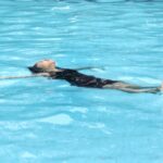 woman in black and white floral swimsuit in water